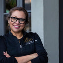 Person wearing a black shirt with visible branding, standing against a neutral background